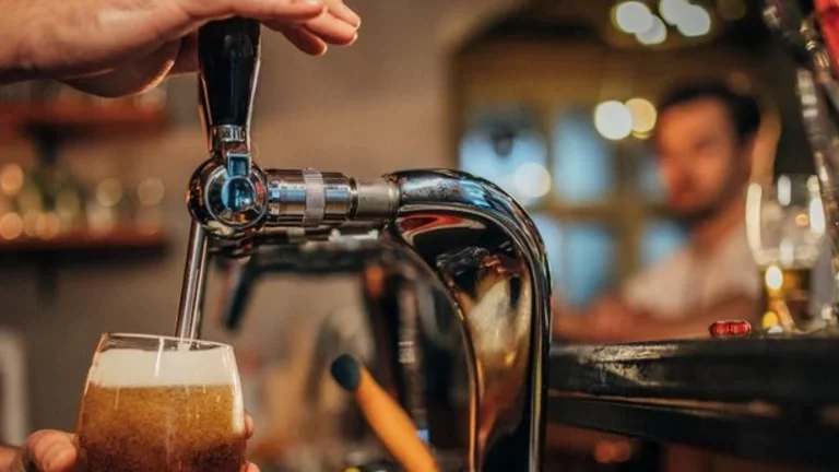 Barman opera uma chopeira para colocar chopp em uma caneca