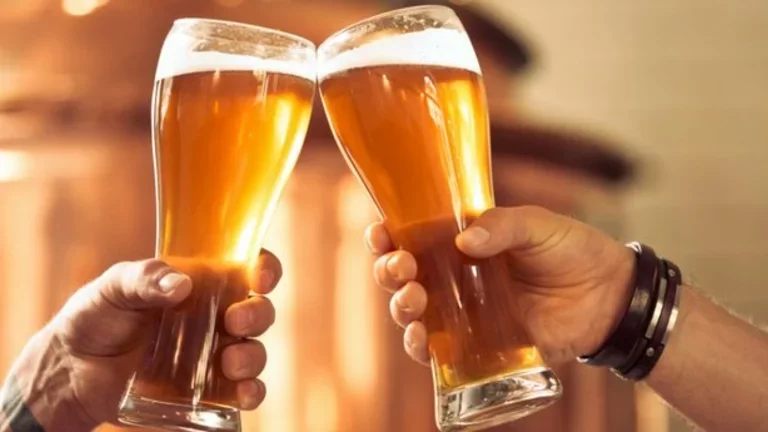 Um brinde entre duas canecas cheias de chopp claro
