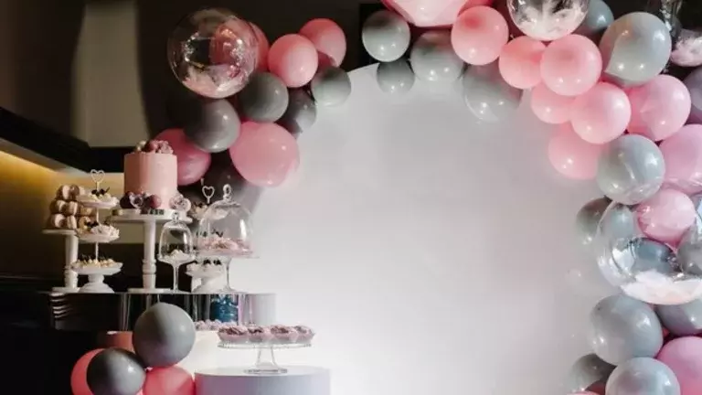 Decoração de festa infantil em tons cinzentos e rosa-claro, e com balões de gás hélio metalizados