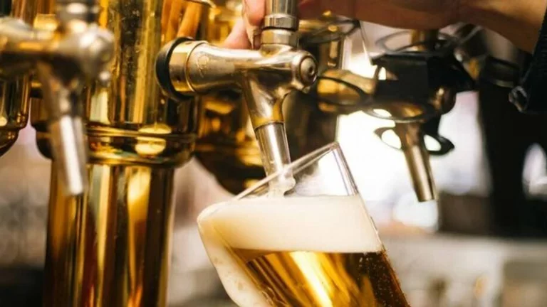 Barman opera uma chopeira para colocar chopp em uma caneca