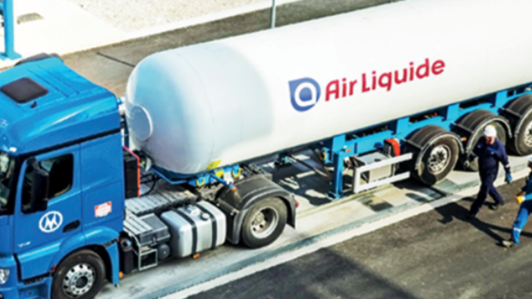 Caminhão da Air Liquide, a cabine é azul-piscina e o cilindro na parte de trás é branco com o logo da empresa