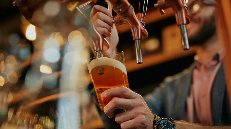 Homem enchendo o copo com chope 