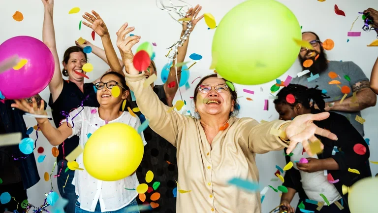 Grupo de pessoas felizes com balões e confetes coloridos 