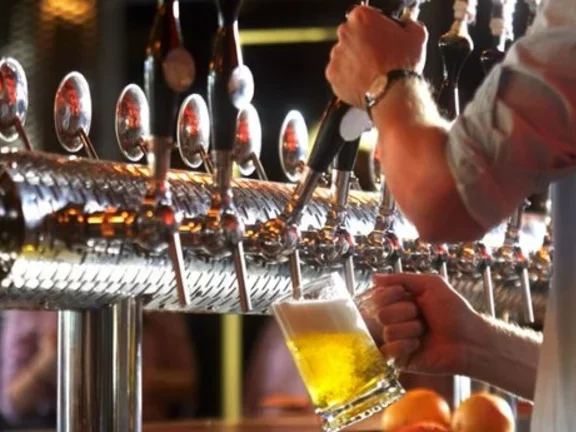 Barman opera uma chopeira para colocar chopp em uma caneca