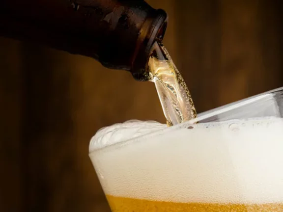 Copo de vidro sendo preenchido com cerveja
