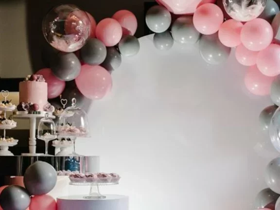 Decoração de festa infantil em tons cinzentos e rosa-claro, e com balões de gás hélio metalizados