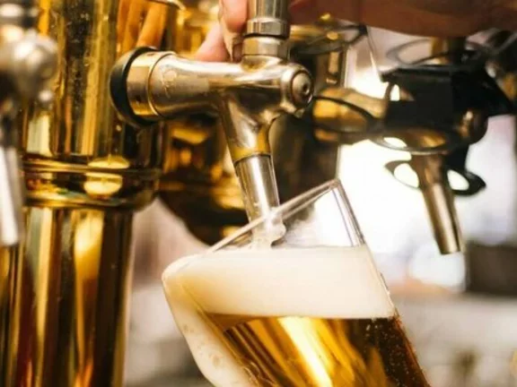 Barman opera uma chopeira para colocar chopp em uma caneca