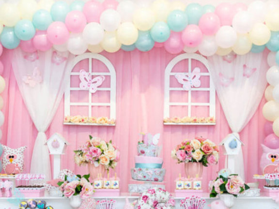 Decoração de festa infantil em tons de rosa-claro e com balões de gás hélio em tons pastéis