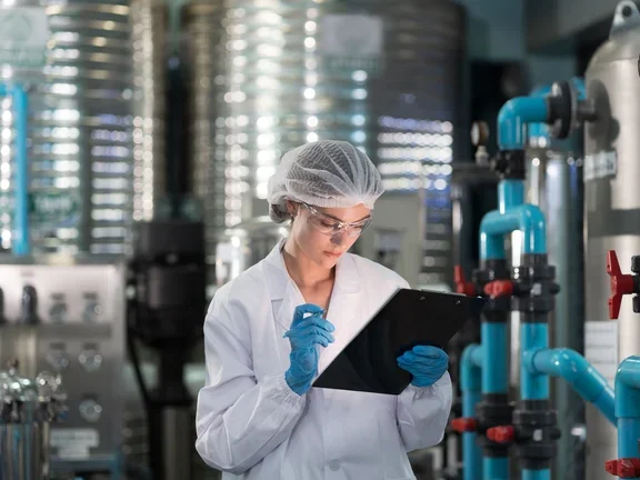 Mulher olhando para prancheta em um laboratório com gases puros