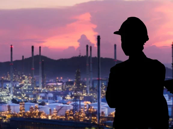 Dois trabalhadores observando uma indústria química