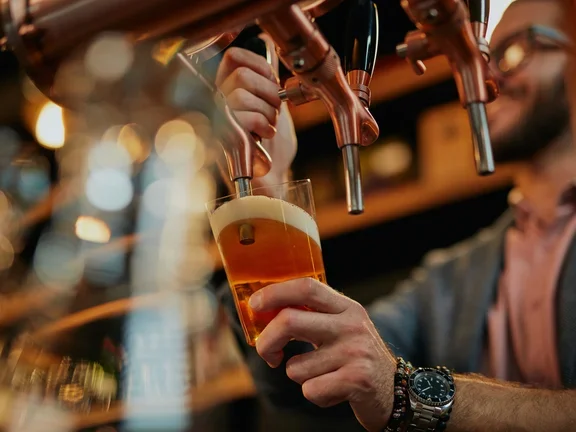Homem enchendo o copo com chope 