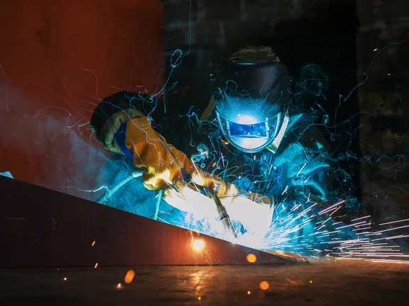 Homem com equipamento adequados e proteção fazendo soldagem 